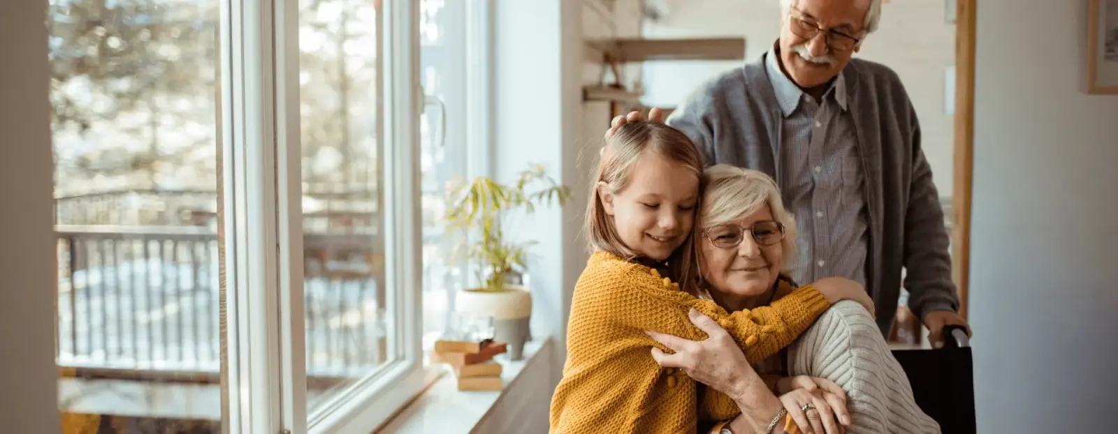 A Synergy HomeCare caregiver sitting with a senior couple at home, sharing a warm afternoon together